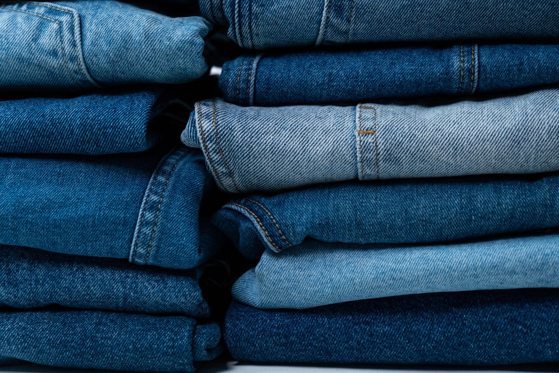 Primer plano de jeans azules apilados con distintas texturas