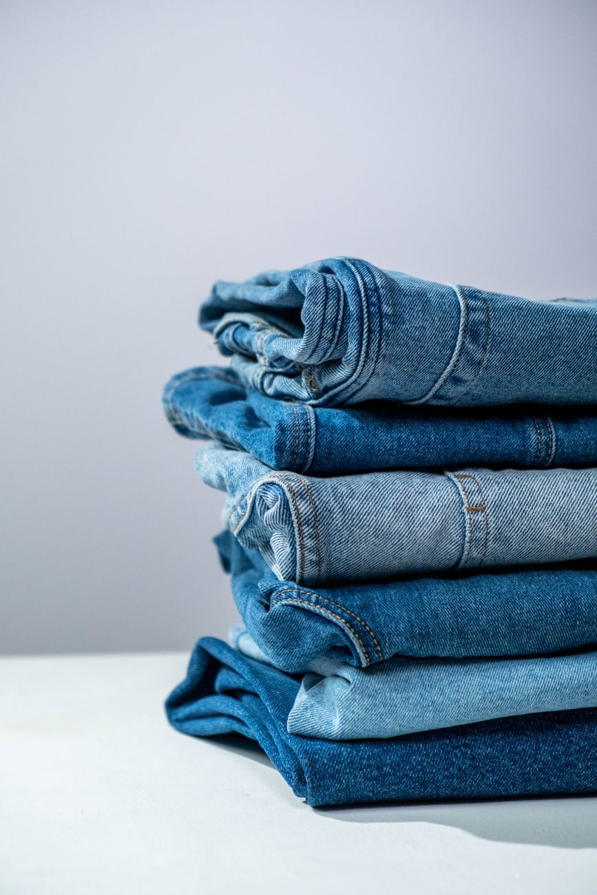 Jeans azules doblados prolijamente sobre una superficie blanca